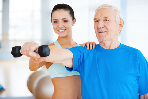 senior man exercising with trainer